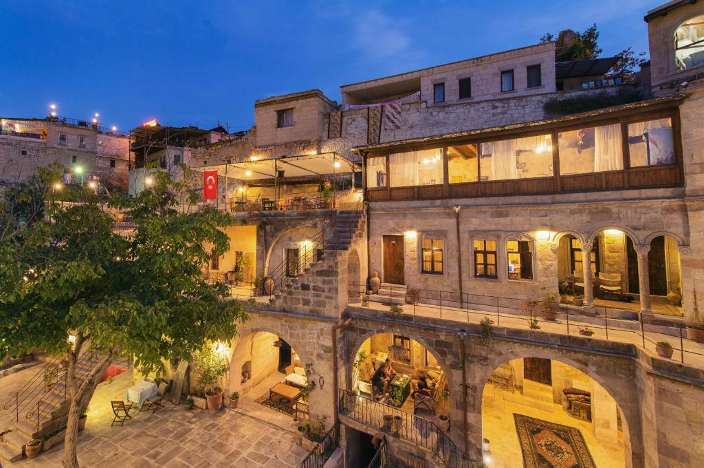 Century Cave Hotel’s illuminated stone facade and courtyard at dusk